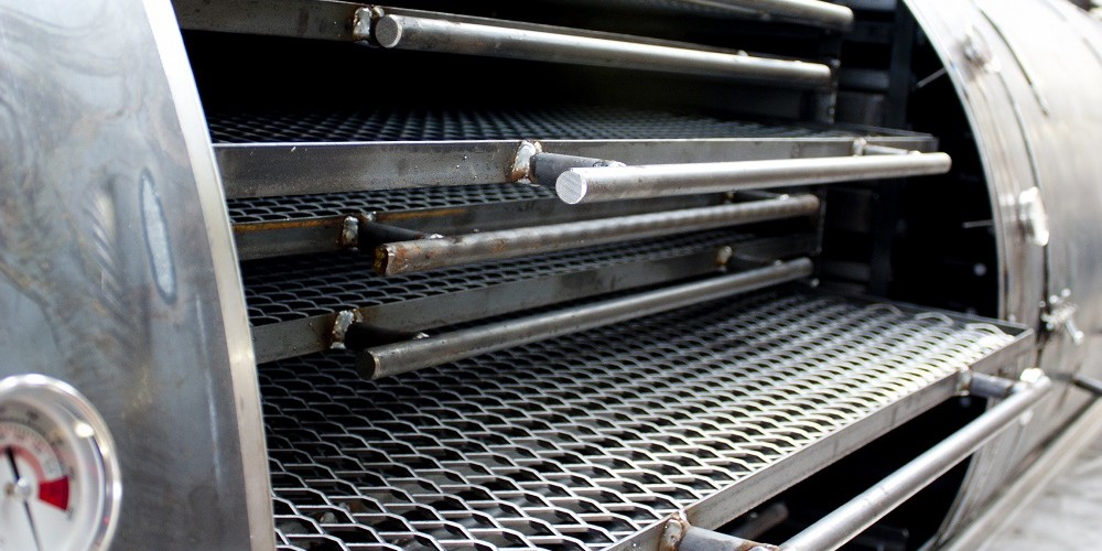 stainless steel cooking grills inside a custom built bbq smoker